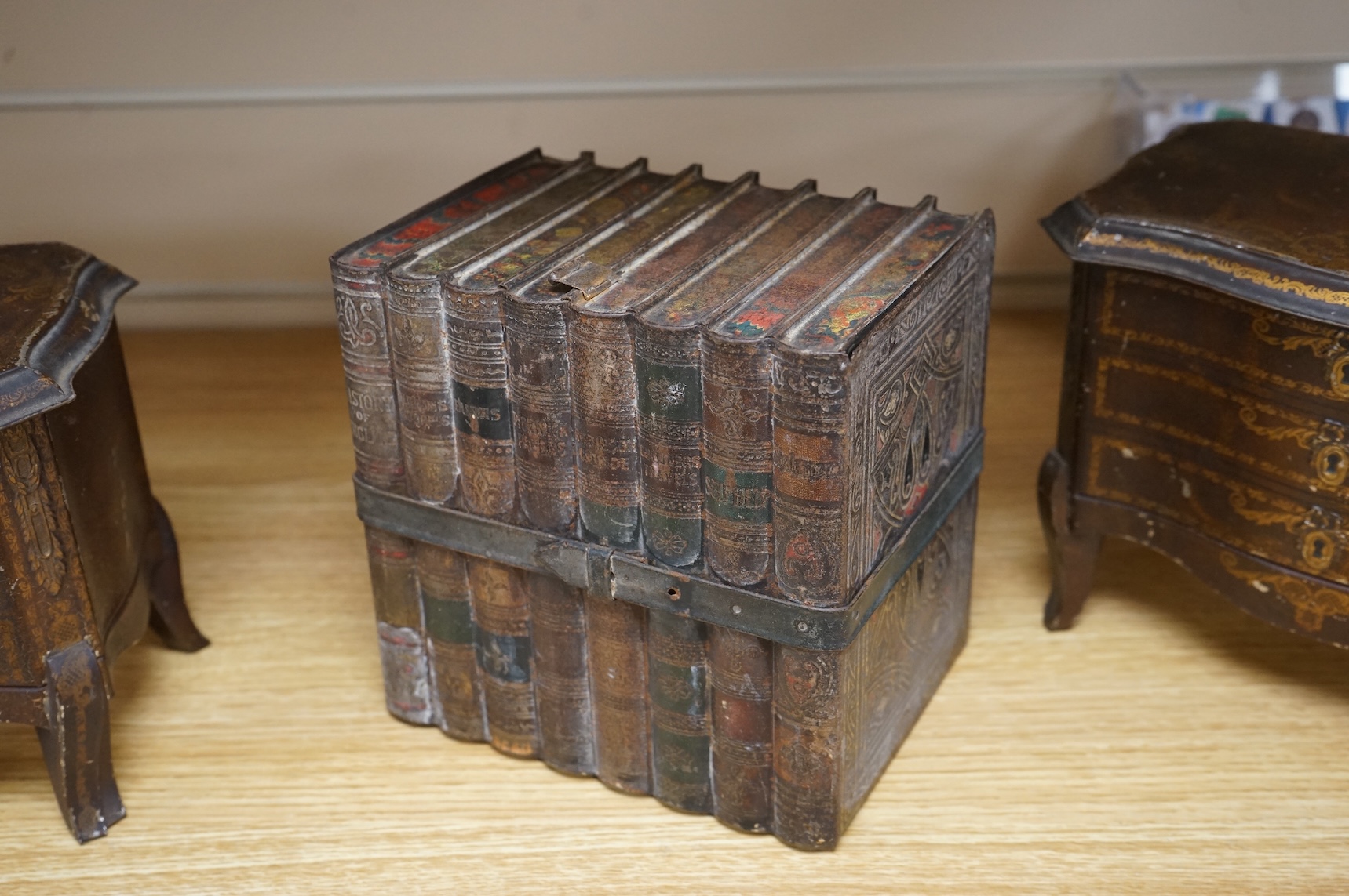 A Huntley and Palmer biscuit tin, modelled as a set of books and and two Mcvitie and Price tins modelled as French chests, tallest 16cm